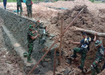 Memanfaatkan Bambu, Anggota Satgas TMMD Percepatan Pemindahan Material Di Tengah Jalan Becek
